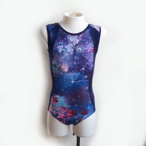 A short-sleeved leotard with dark blue, pink and purple floral galaxy print and navy panels down the sides